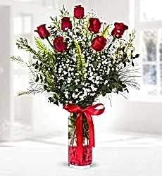 Vazoda 7 Kırmızı Gül Silindir cam vazo içerisinde kırmızı gül, cipsofilya ve yeşillikler ile hazırlanmıştır.