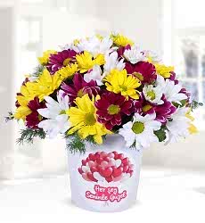 Renkli Papatyalar Her şey seninle güzel temalı seramik vazo içerisinde beyaz papatya, pembe papatya, sarı papatya ve yeşillikler ile hazırlanmıştır.