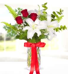 Lilyum Kırmızı Gül Zarif cam vazo içerisinde beyaz lilyum, kırmızı gül, cipsofilya ve yeşillikler ile hazırlanmıştır.