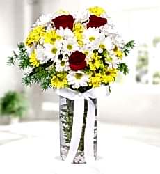 Renkli Papatyalar Kırmızı Güller Silindir cam vazo içerisinde renkli papatya ve kırmızı gül ve yeşillikler ile hazırlanmıştır.