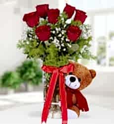 Vazoda 7 Kırmızı Gül Ayıcık Silindir cam vazo içerisinde kırmızı gül, peluş oyuncak, cipsofilya ve yeşillikler ile hazırlanmıştır.